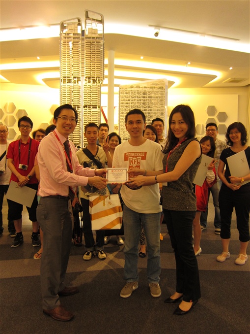 圖7: 新加坡中原地產副總裁 Kerr Sun (左) 及 Shirley Ong (右) 親自帶領一眾理財精英參觀當地最新樓盤之示範單位，中原理財香港區總經理 Franki Lee 送上紀念品答謝。