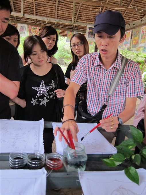 圖4: 同事們在用心聆聽導遊Louis (右一)講解臘染技巧，以準備稍後的比賽。